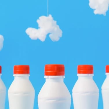 4 milkbottles with a sky background