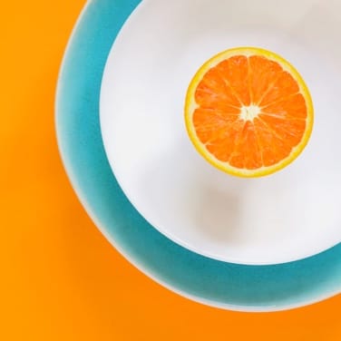 Top view of orange on a bowl on a orange table